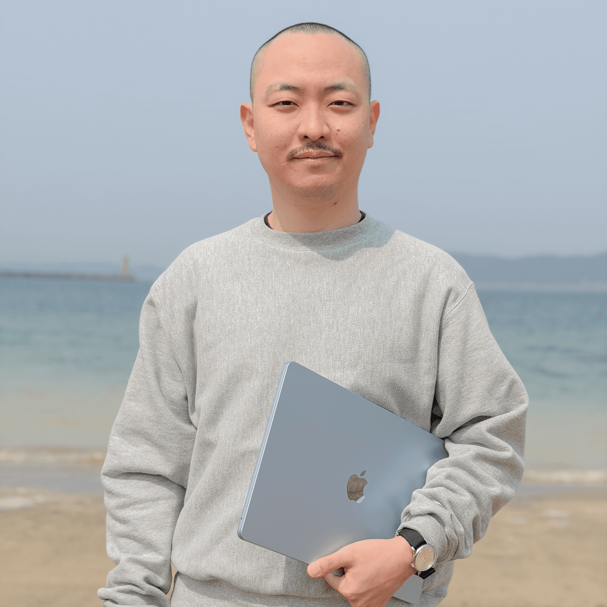 和歌山の港を背景に立つKaze代表の中村仁